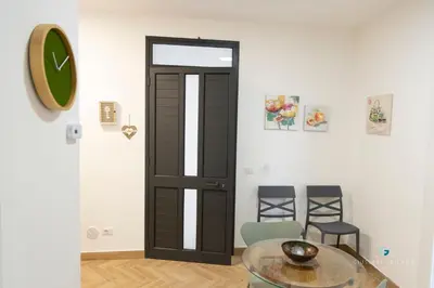 a room with a door and a glass table and chairs at ESSE Homes Sant Elia in Santa Flavia