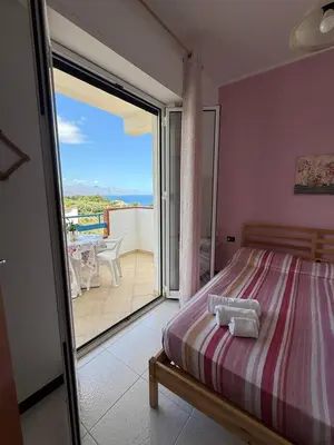 a bedroom with a bed and a balcony with a view at 
