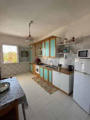 a kitchen with a white refrigerator and a table at 