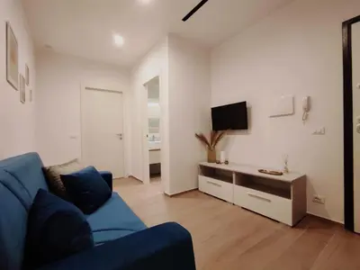 a living room with a blue couch and a tv at Appartamento Dante 2 in Alcamo