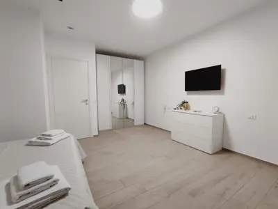 a white room with a bed and a television at Appartamento Dante 2 in Alcamo