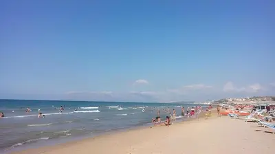 a group of people on a beach near the ocean at Stella Del Mare in Castellammare del Golfo