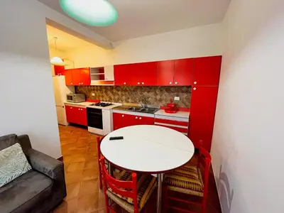 a kitchen with red cabinets and a white table at Casa Vacanza Acquanuova in Calatafimi