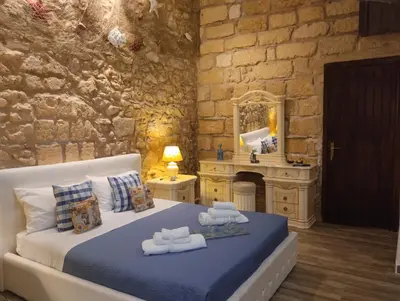 a bedroom with a bed and a stone wall at Il rustico del pescatore in Balestrate