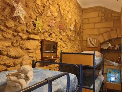 a room with two bunk beds and a stone wall at Il rustico del pescatore in Balestrate
