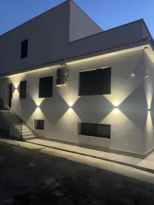 a white building with a mountain in the background at kalispera in Cinisi