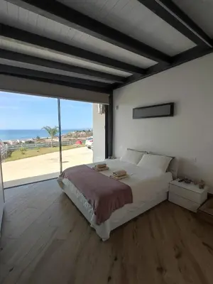 a bedroom with a large bed and a large window at Villa Mare Luna in Balestrate