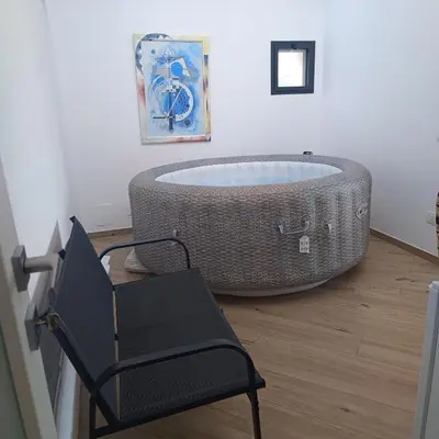 a bath tub in a room with a chair at Villa Mare Luna in Balestrate