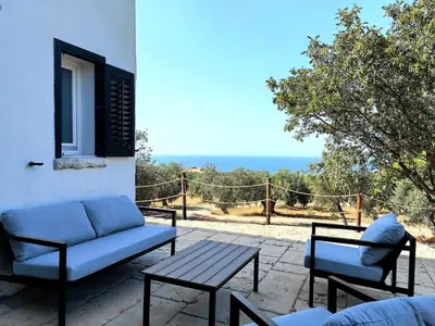 a patio with a couch and a table and a view at Villa Teleffio in Castellammare del Golfo