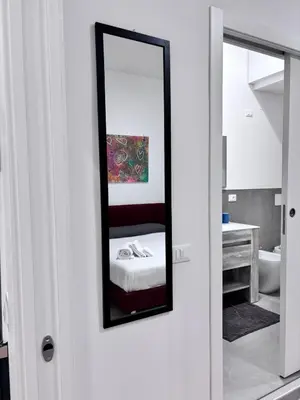 a mirror on the wall of a room with a bed at Almarè Mondello in Mondello