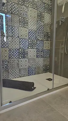 a shower with a glass door with a tile wall at Almarè Mondello in Mondello