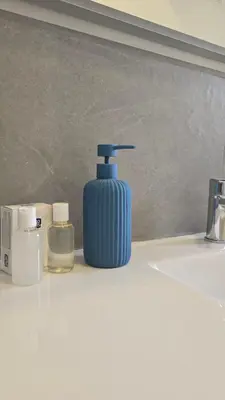 a blue soap dispenser sitting on a bathroom sink at Almarè Mondello in Mondello