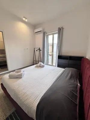 a bedroom with a large white bed with a window at Almarè Mondello in Mondello