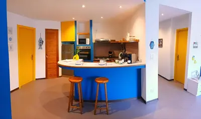 a kitchen with a blue island with two bar stools at Casa Cavarretta in Palermo
