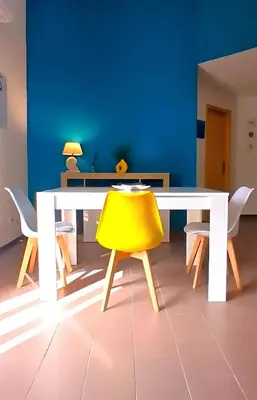 a white table with a yellow chair in a room at Casa Cavarretta in Palermo