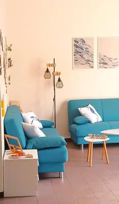a living room with two blue couches and a table at Casa Cavarretta in Palermo