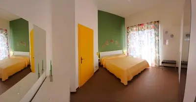 two beds in a room with green and yellow walls at Casa Cavarretta in Palermo