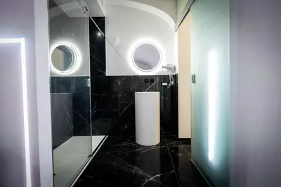 a bathroom with two windows and a black tile floor at Palermo Luxury Rooms Black in Palermo