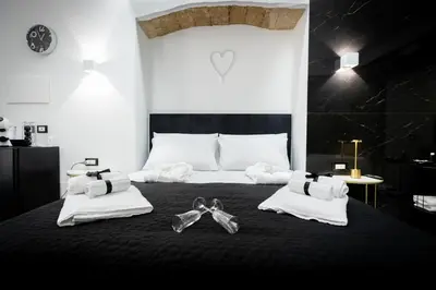 a bedroom with a bed with towels and shoes on it at Palermo Luxury Rooms White in Palermo
