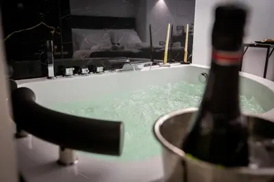 a bath tub with a bottle of champagne in it at Palermo Luxury Rooms White in Palermo