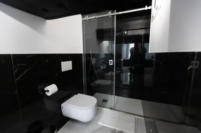a bathroom with a toilet and a glass shower at Palermo Luxury Rooms White in Palermo