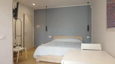 a bedroom with a bed and a table and a chair at Le Stanze del Massimo in Palermo