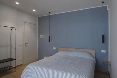a bedroom with a bed and a blue wall at Le Stanze del Massimo in Palermo