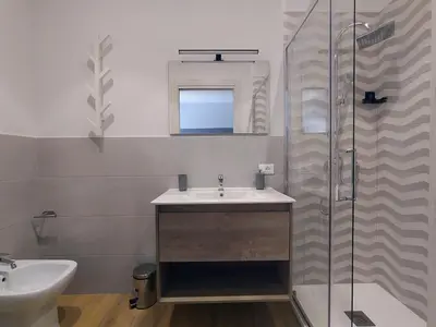 a bathroom with a sink and a glass shower at Le Stanze del Massimo in Palermo