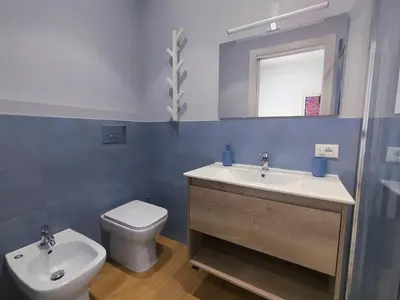 a bathroom with a sink and a toilet and a mirror at Le Stanze del Massimo in Palermo