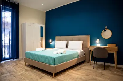 a bedroom with a bed with a blue wall at Porta Reale RooM in Palermo