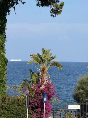 a white table with a vase of flowers on a balcony at Mondello Sunshine Apartment in Mondello