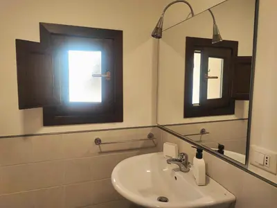 a bathroom with a sink and a mirror and a window at Il rifugio del Capo in Palermo