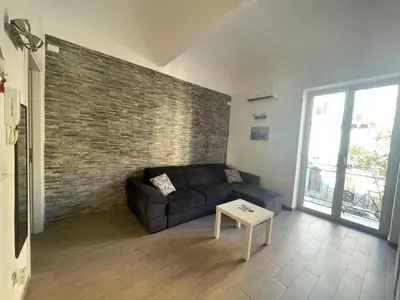 a living room with a couch and a brick wall at Dimora Normanna in Palermo