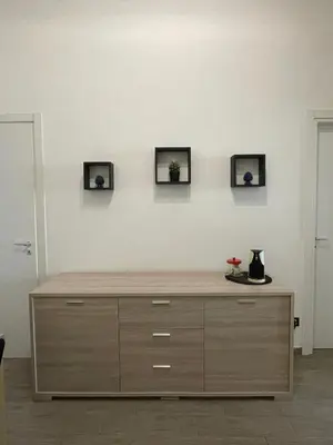 a dresser in a room with three pictures on the wall at Dimora Normanna in Palermo
