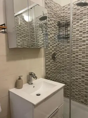 a white bathroom with a sink and a shower at Dimora Normanna in Palermo