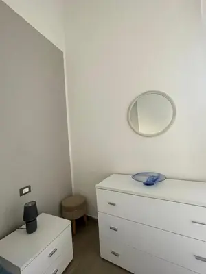 a bedroom with a white dresser and a mirror at Dimora Normanna in Palermo