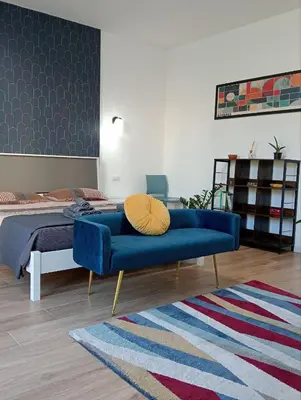 a living room with a blue couch and a bed at The Junction in Palermo