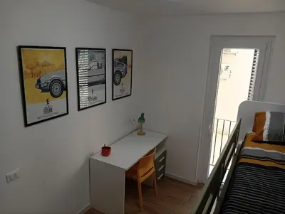 a bedroom with a desk and pictures on the wall at The Junction in Palermo