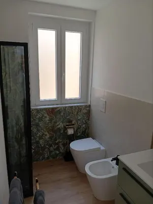 a bathroom with a toilet and a sink and a window at The Junction in Palermo