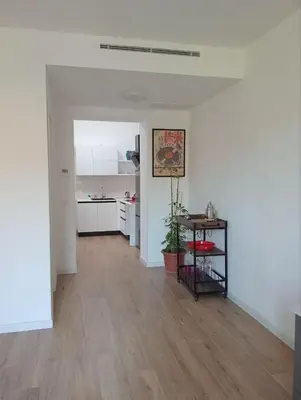 an empty living room with a table and a kitchen at The Junction in Palermo