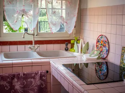 a pink tiled kitchen with a sink and a mirror at Casa Melina in Palermo