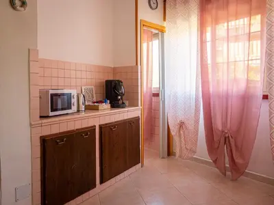 a kitchen with a microwave on a counter and a window at Casa Melina in Palermo