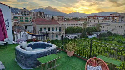 a hot tub on a balcony with a view of a city at Cottage I Sollazzi in Palermo