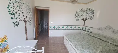 a bedroom with a bed and trees on the wall at Cottage I Sollazzi in Palermo