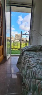 a bedroom with a bed and a large glass window at Cottage I Sollazzi in Palermo