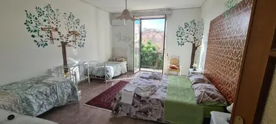 a room with two beds and a cross on the wall at Cottage I Sollazzi in Palermo