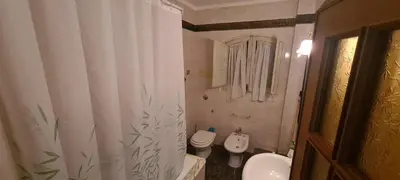 a bathroom with a toilet and a shower curtain at Cottage I Sollazzi in Palermo