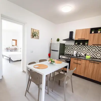 a kitchen and dining room with a white table and chairs at Borgo di Mare in Palermo