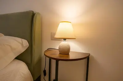 a lamp sitting on a table next to a bed at Borgo di Mare in Palermo
