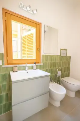 a bathroom with a sink and a toilet and a window at Borgo di Mare in Palermo